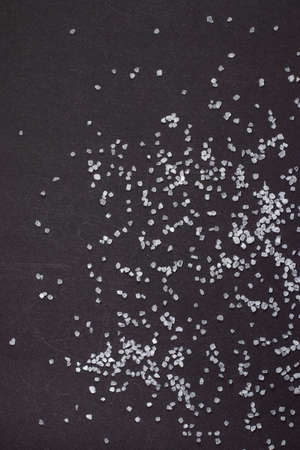 Spilled white sea salt on a black background. clear crystalline pebbles on a black background.の写真素材