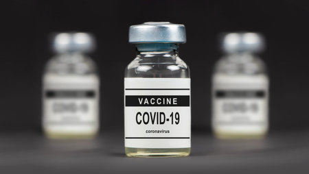 Covid-19 vaccine on a laboratory bench. to fight the coronavirus sars-cov-2 pandemic. dark...