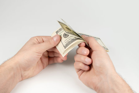 American dollars or US dollars: hand counting one hundred American money or 100 USD.