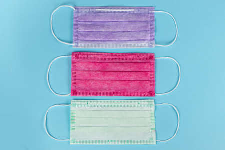 Different colored medical masks on blue background.の写真素材