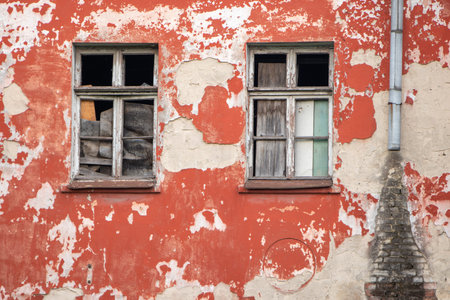 Broken old window on the red wall.