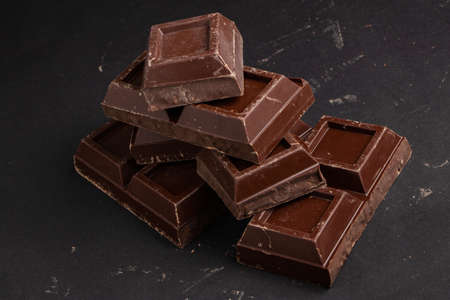Pieces of dark chocolate on a dark background.の写真素材