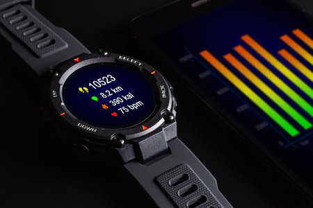 Black smart watch on the smartphone. Closeup, selective focus.の写真素材