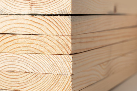 Stacks of pine wood planks on white. Natural rough wooden boards boards, lumber, industrial wood, timber.の写真素材