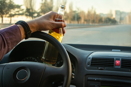 Man drinking alcohol while driving in his car.の写真素材