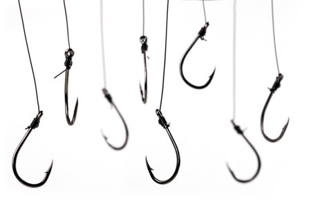 Fishing hooks hanging on a fishing line on a white background. conceptの写真素材
