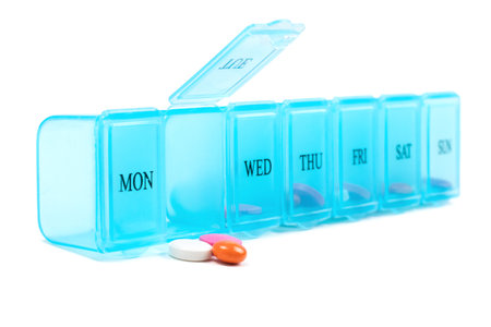 Pill organizer with pills on white.の写真素材