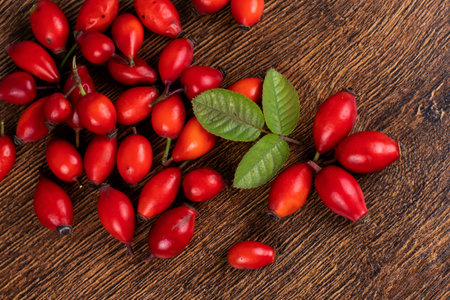 Rose hips with leaves on wooden backgroundの写真素材