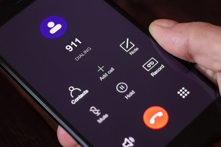 Dialing 911, call 911. Emergency concept: man using a digital phone with emergency call on the screen. All screen graphics are made upの写真素材