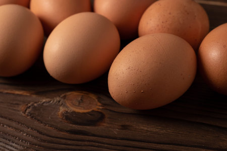 Fresh farm eggs on a wooden rustic background.