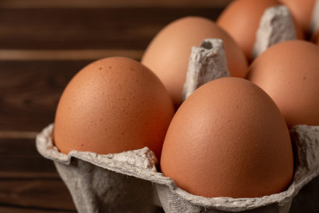 Happy Easter. Easter eggs. Chicken brown eggs closeup top view On the table. A carton crate of fresh...