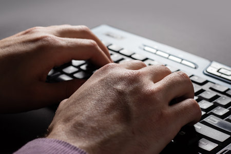 Hands working on computer, typing keyboard, planning work project in modern office, close up. Executive manager, corporate man proofing business report on deskの写真素材
