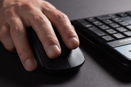 Hand using computer mouse, clicking pointer pc peripheral, close up.