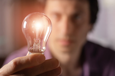 Man holding light bulb in hand. idea concept with innovation and inspiration.の写真素材