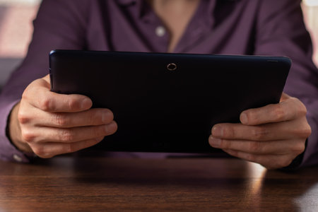 close up hands multitasking man using tablet, laptop and cellphone connecting wifi.の写真素材