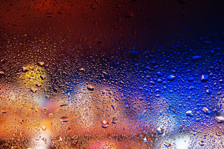 Water drops and condensation in a window glass. Abstract background niglt light.の写真素材