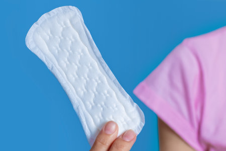 Girl holding in hand hygiene pad on blue background.の写真素材