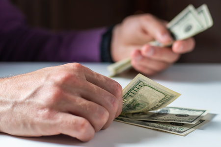 Close up male hand Counting money us dollar. financial business conceptの写真素材