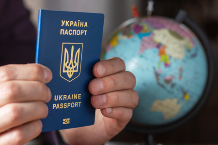 Ukraine, passport. Ukrainian passports in hands are on the world map. travel conceptの写真素材