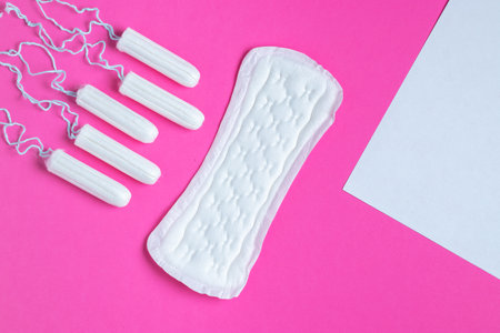 Menstrual tampons and pads on a pink background. menstruation cycle. hygiene and protection. copyspace.の写真素材