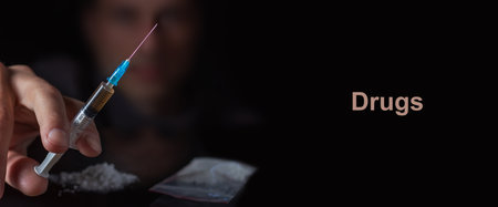 Drug syringe in hand. A drug addict with another dose of the drug in the syringe. Guy addicted, The concept of anti drugs. male drug addict.の写真素材