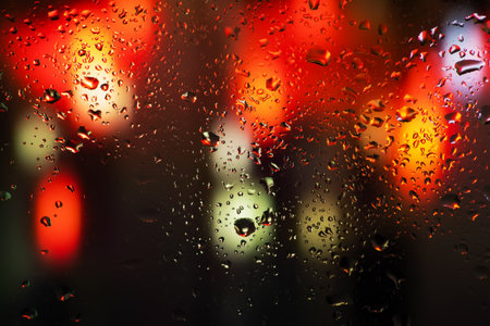Water drops and condensation in a window glass. Abstract background niglt light.の写真素材