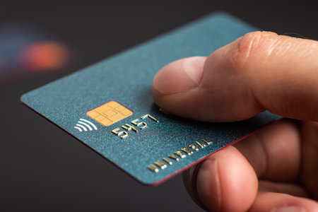 Blue credit card held by hand. focus on card.の写真素材