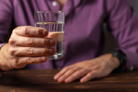 Man drinking from a glass of water. Health care concept photo, lifestyle, close up.の写真素材