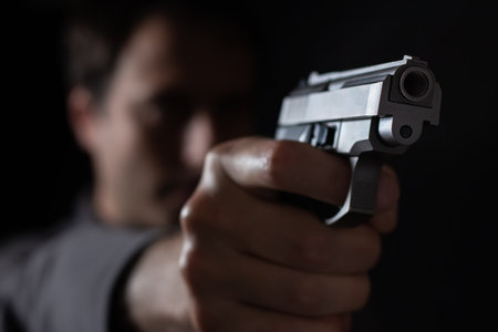 give me your money. Blur robber aiming with pistol the victim. Armed man thief killer holds gun. weapon, crimeの写真素材
