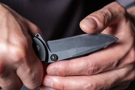 Man holding a knife in a threatening stance ready to fight.の写真素材