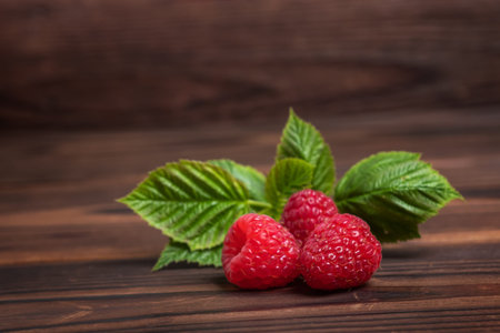 Harvested red raspberries, large red garden raspberries on wooden background.