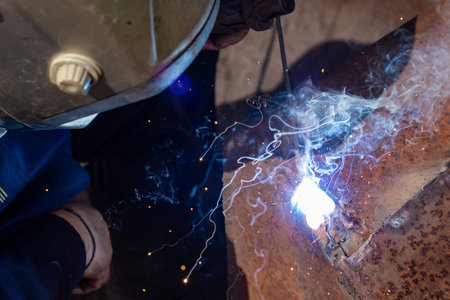 The man makes electric welding at home
