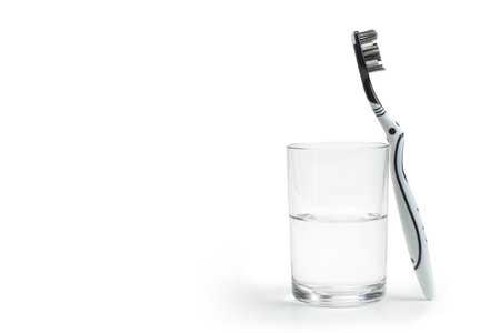 Toothbrush and a glass with water on white. copyspace.の写真素材