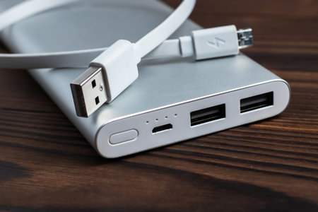 Power bank for charging mobile devices on wooden background. battery bank. External battery for mobile devicesの写真素材