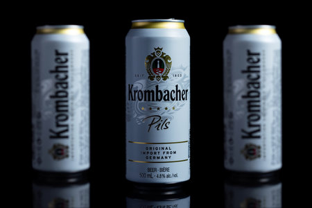 Dnipro Ukraine - 29 August 2022: Krombacher Pils beer brand cans on black background. Krombacher beer brand, produced at the brewery of the company Krombacher Brauerei GmbH Co. kg.のeditorial素材