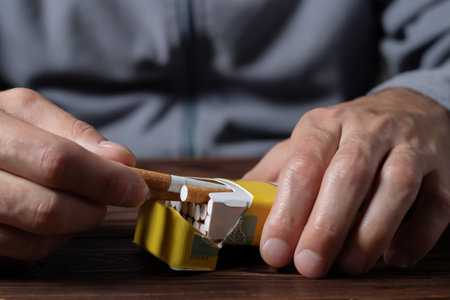 close up man hand holding peel it off cigarette pack prepare smoking a cigarette. Packing line up.の写真素材