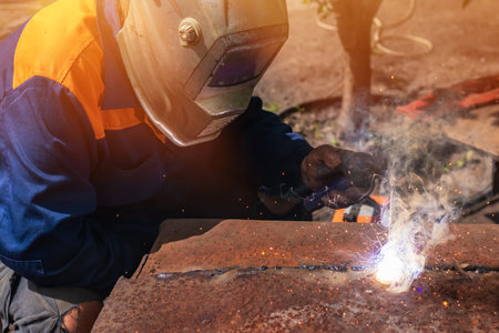 Worker wearing industrial uniforms and Welded Mask industrial safety first conceptの写真素材