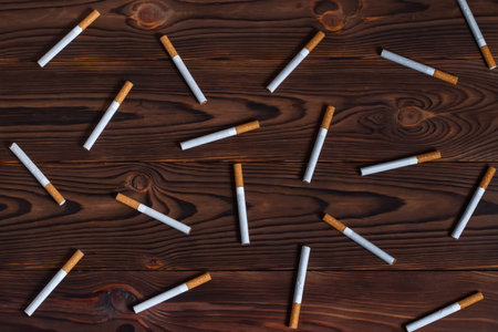 A smoking cigarettes on wooden background. cigarette filter tubes. top view.
