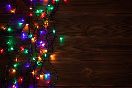 Christmas background with lights and free text space. christmas lights border. Glowing colorful Christmas lights on wooden background. new year. Christmas. decor. Garland.の写真素材