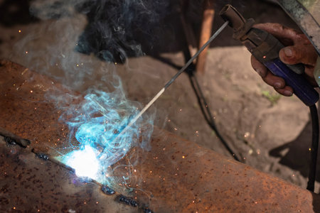 The man makes electric welding at home