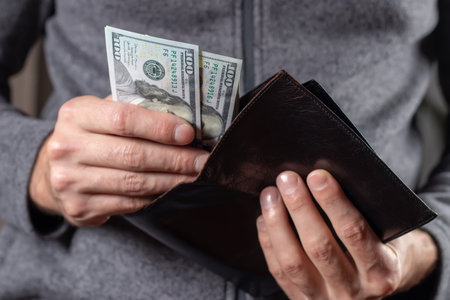 Close up male hand open the wallet.He has lot money us dollar in wallet. financial business concept