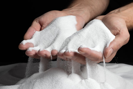 Men's hands keep sand in their palms and spilling grains of sand through their fingers. Concept of the flow of lifeの写真素材