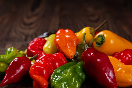Colored hot peppers on a wooden surface
