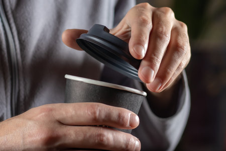 Man open paper cup of coffee close up.