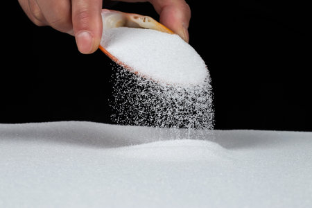 sand pouring out of sea shells on black background.の写真素材