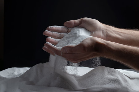 sand running through hands as a symbol for time running.