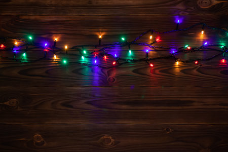 Christmas background with lights and free text space. christmas lights border. Glowing colorful Christmas lights on wooden background. new year. Christmas. decor. Garland.の写真素材