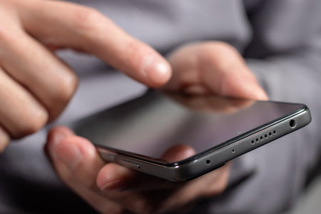 Close up of a man using mobile smart phone.