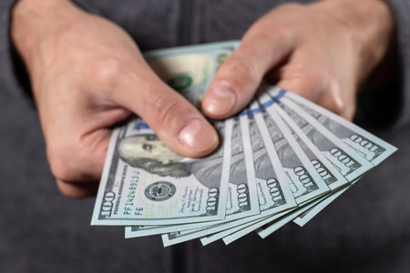 American 100 dollars bank note in hand close up.の写真素材