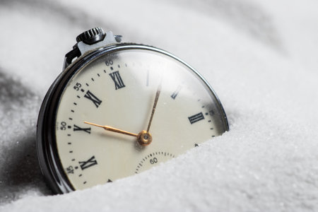 Pocket watch buried in sand. Old watch lost in the sandの写真素材